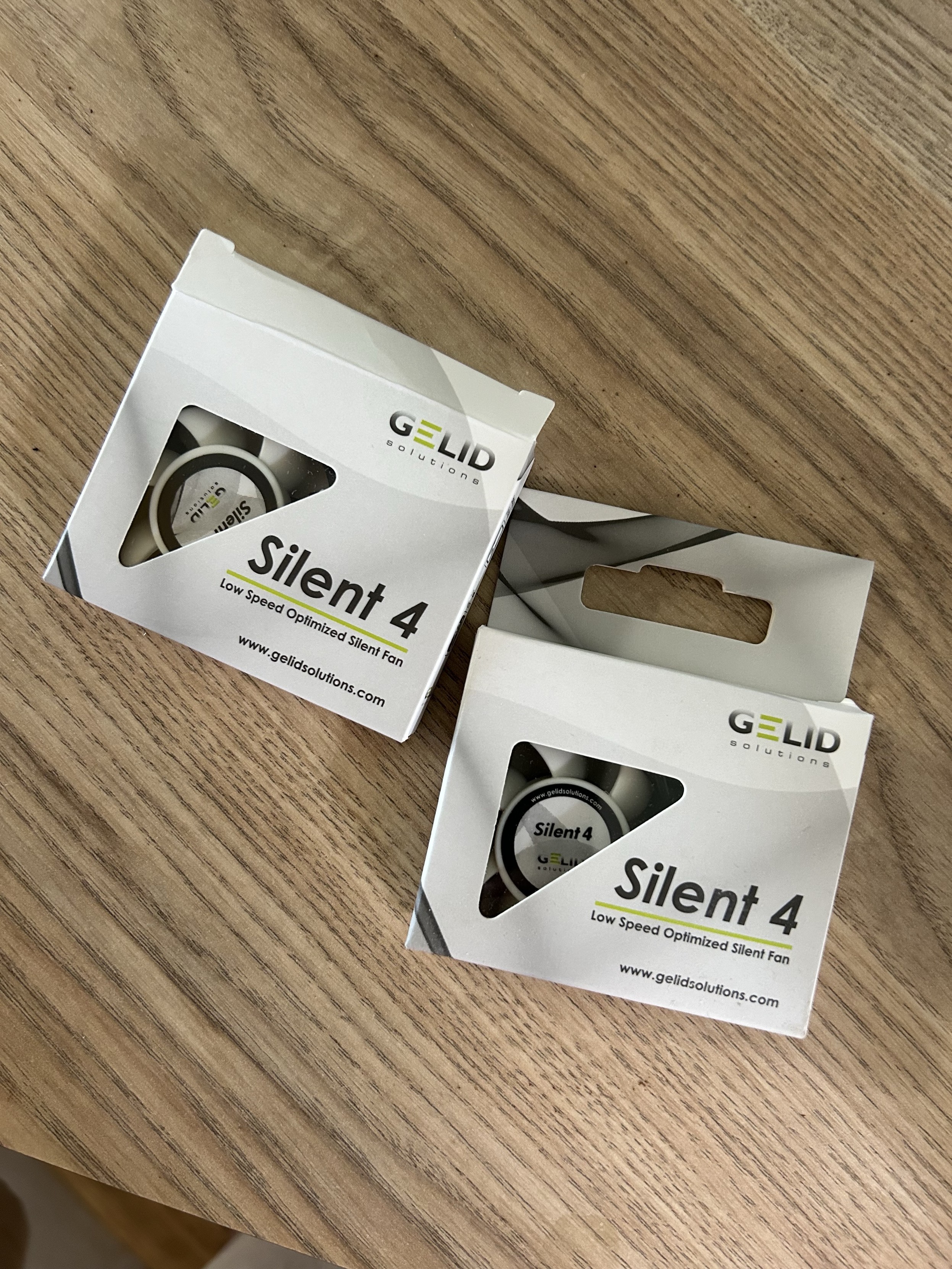 Dwa pudełka Gelid Silent 4 na drewnianej powierzchni.